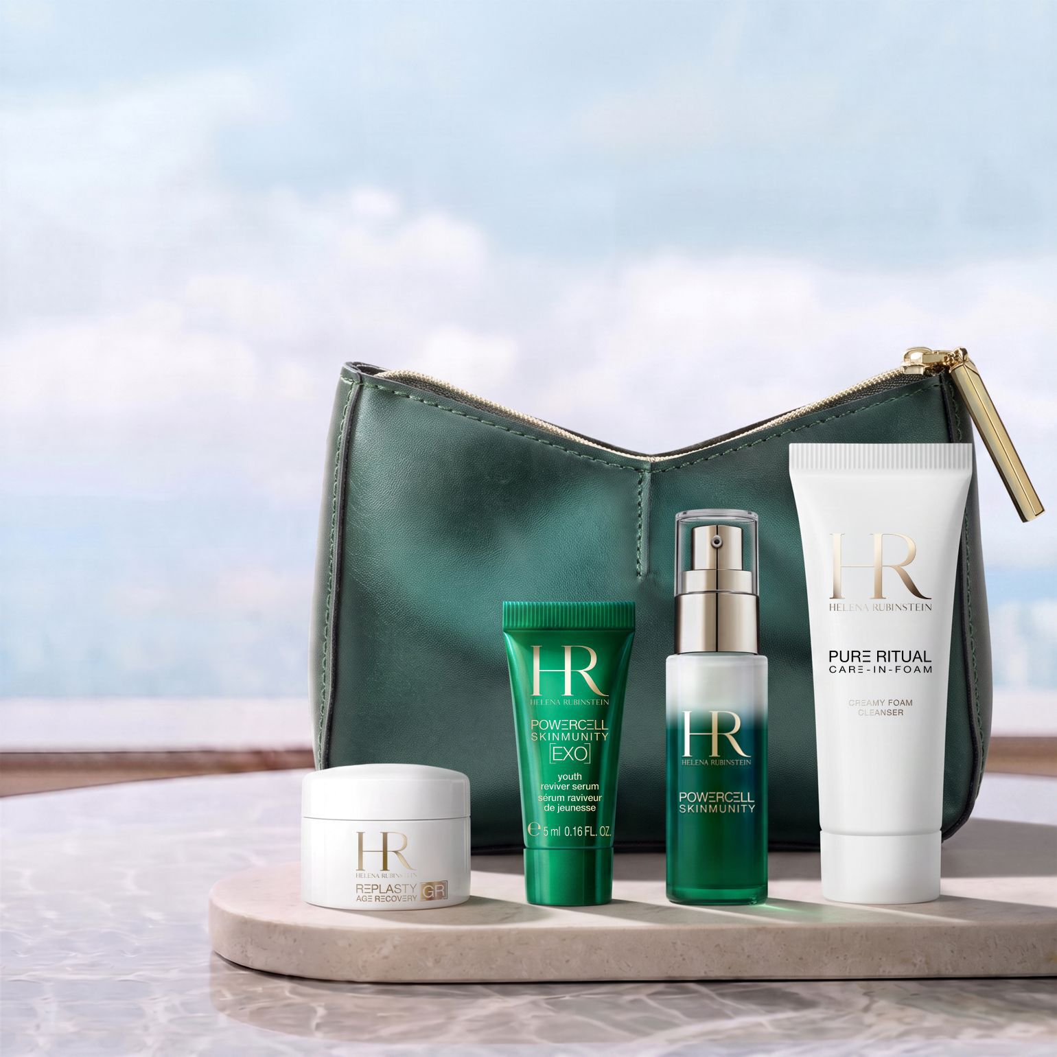 Un neceser verde de Helena Rubinstein colocado ante un paisaje luminoso, rodeado de cuatro productos en miniatura: una crema Re-Plasty, un mini serum Powercell [EXO], un serum Powercell Skinmunity y un limpiador Pure Ritual.​