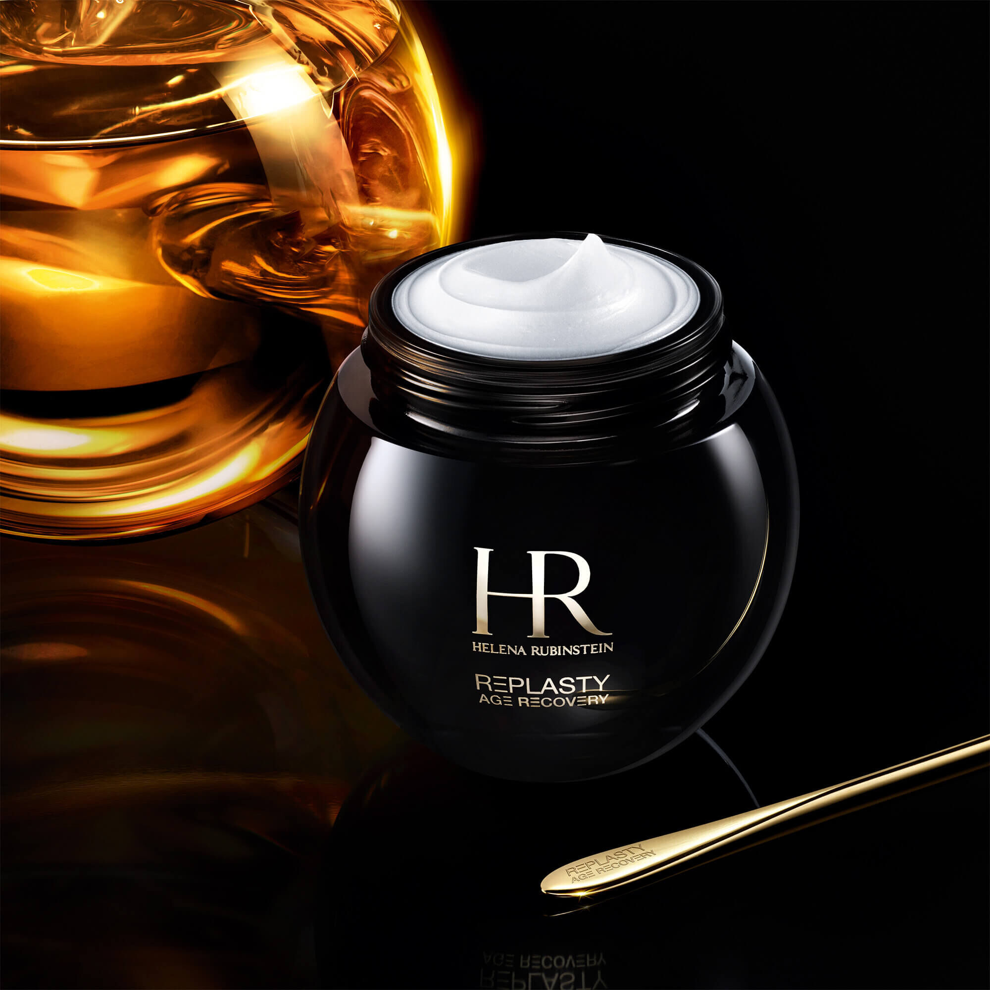 Tarro abierto de la crema Helena Rubinstein Replasty Age Recovery Night 30PX con una molecula dorada sobre un fondo negro