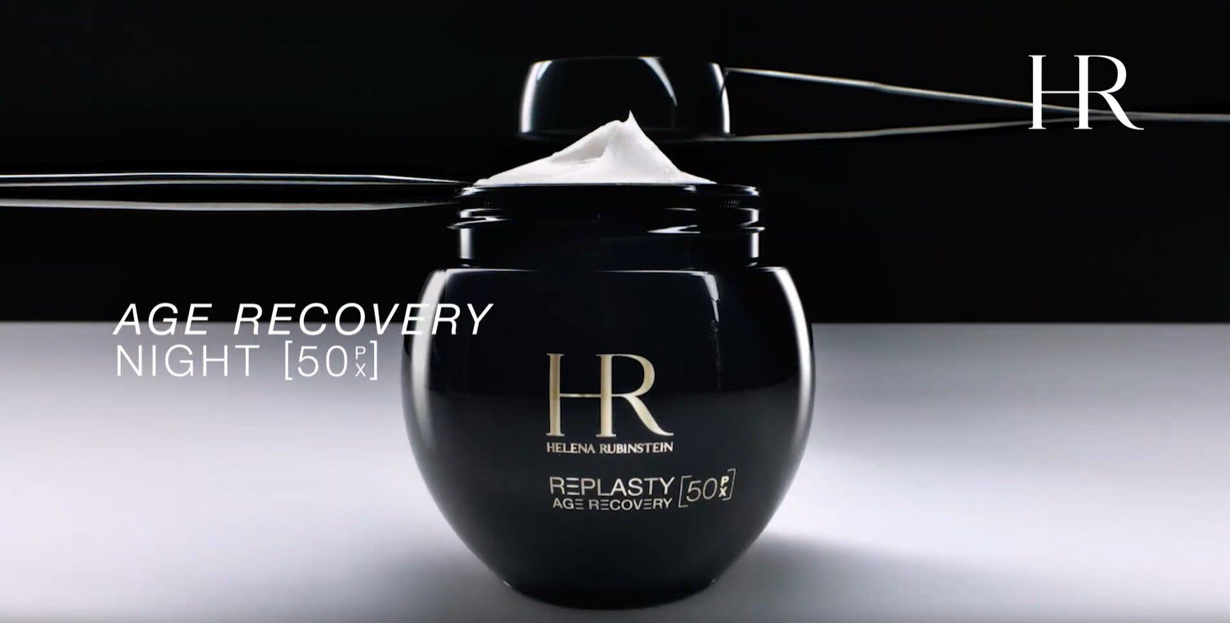 Video del nuevo tarro recargable Helena Rubinstein Re-Plasty Age Recovery [50PX], abierto con la crema visible en el interior, presentado sobre un fondo oscuro.​