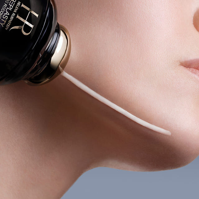 Aplicador de Helena Rubinstein Replasty Eye & Face Contour Concentrate dispensando crema en la mejilla de una mujer.