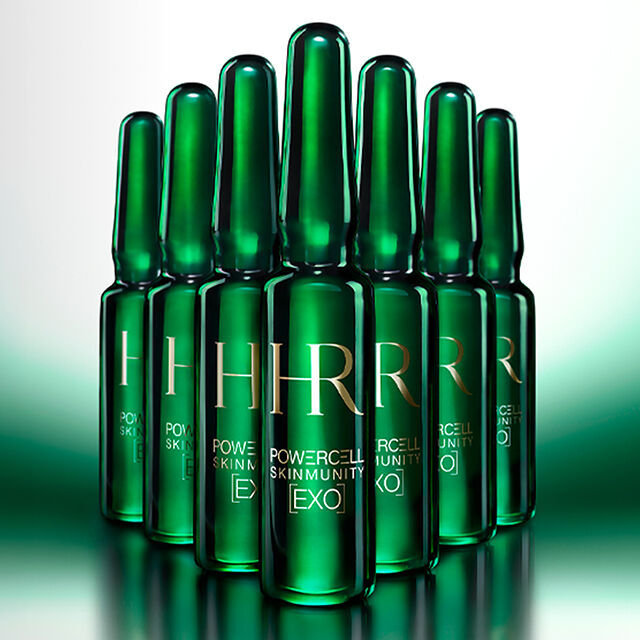 7 ampollas verdes en primer plano sobre un fondo verde iluminado.