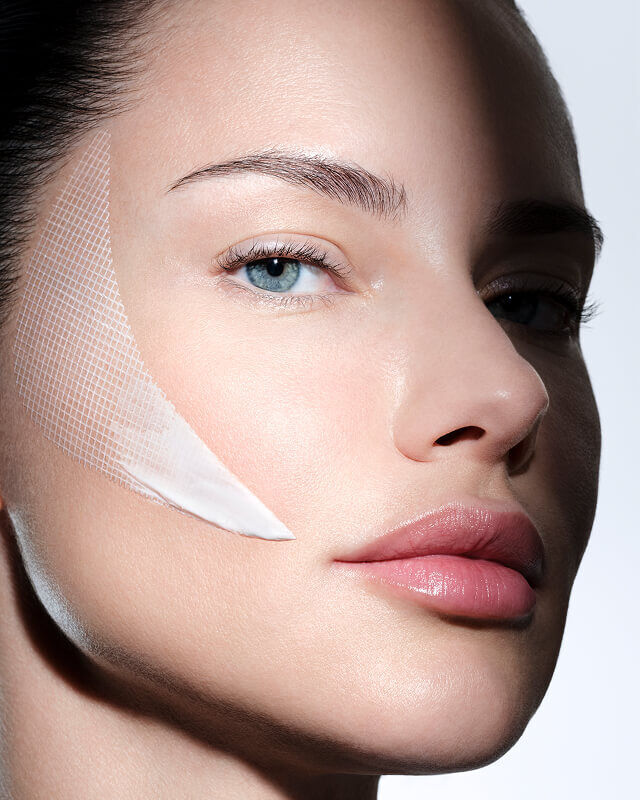 Rostro femenino con la crema Helena Rubinstein REPLASTY y su innovadora textura efecto venda en la mejilla.