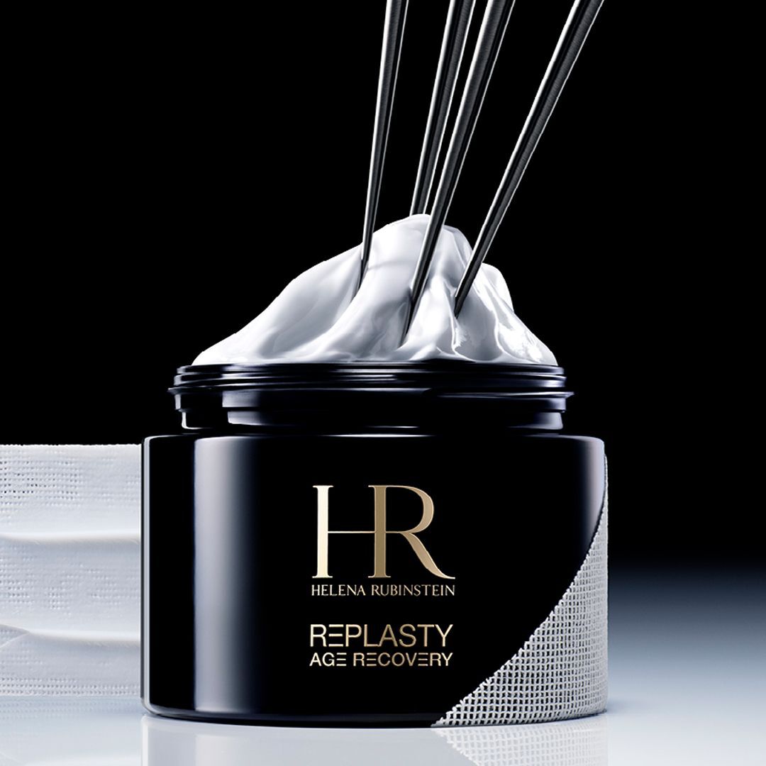 Banner Helena Rubinstein Re-Plasty Age Recovery: elegante tarro de crema negro, centrado, con reflejos dorados y elementos liquidos ambar en el fondo. Ambiente oscuro y lujoso.​