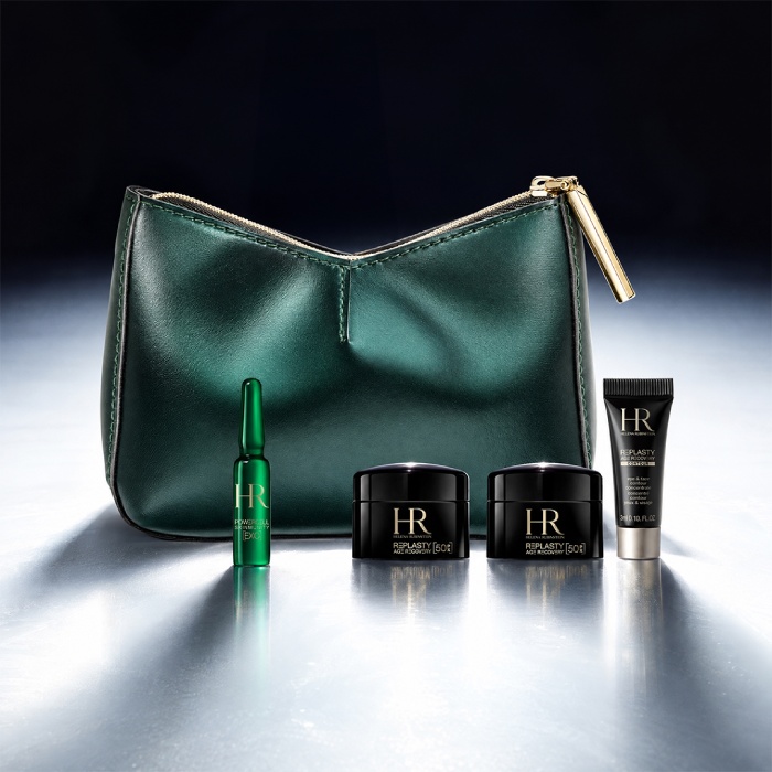 Un neceser verde de Helena Rubinstein colocado ante un paisaje luminoso, rodeado de cuatro productos en miniatura.